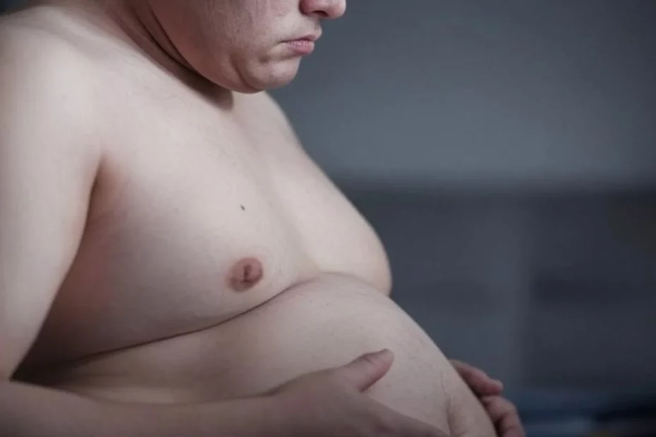 alt="Homme tenant son ventre arrondi, illustrant la prise de poids et les enjeux de la remise en forme.